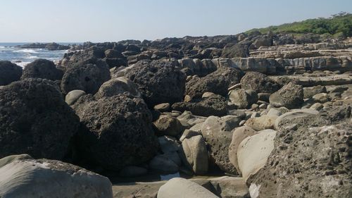 Rocks on beach against clear sky