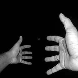 Cropped image of hand holding over black background