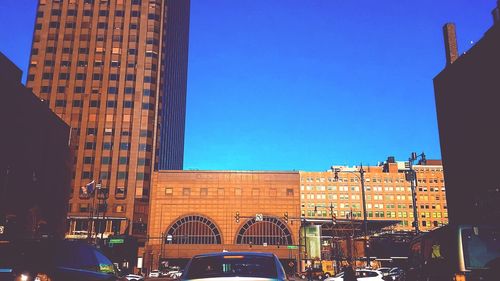 Buildings in city against clear blue sky