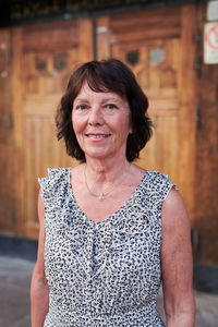 Portrait of senior female student standing outside language school