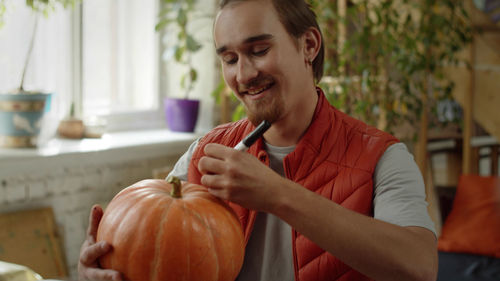 Portrait of man holding pumpkin