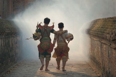 Rear view of man and woman walking on road