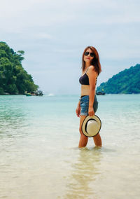 Portrait of woman on beach against sky