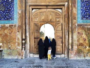 Rear view of women with child at entrance of mosque