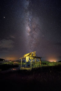 Old built structure on land against sky at night