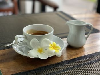 Close-up of white and coffee served on table