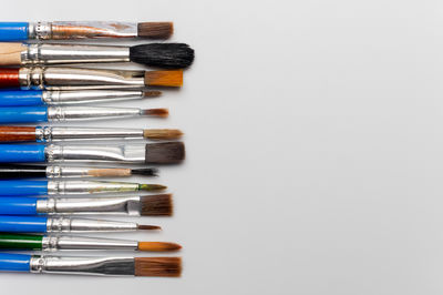 High angle view of paintbrushes on white background