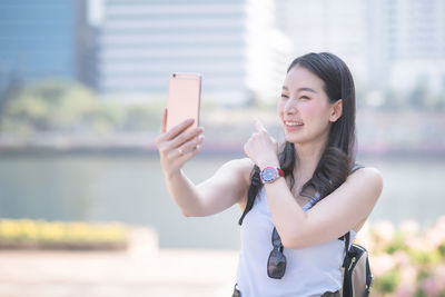 Young woman photographing with mobile phone