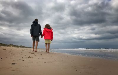 Rear view of women walking on beach