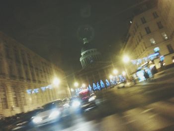 Cars on illuminated road in city at night