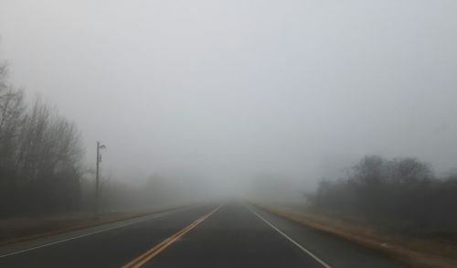 Road in foggy weather against sky during winter