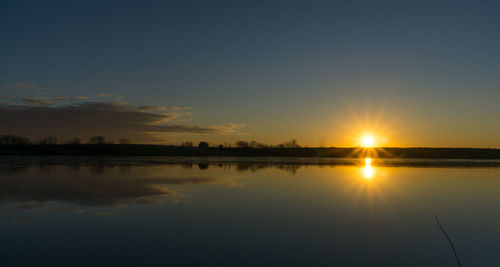 Scenic view of lake at sunset