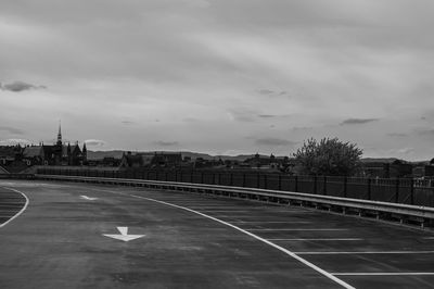 Road leading towards city against sky