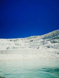 Scenic view of snowcapped mountains against clear blue sky