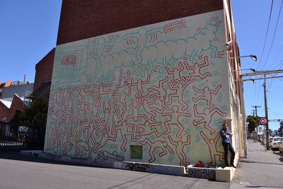 Graffiti on building against sky in city