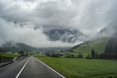 Road by mountains against sky