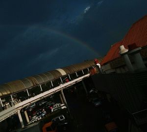Aerial view of rainbow over buildings in city at night