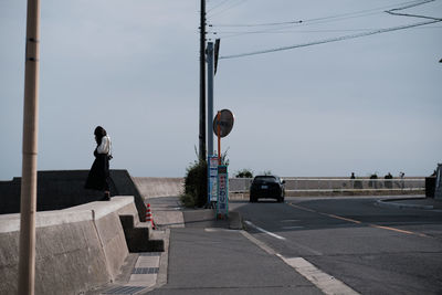 Rear view of man on road against sky