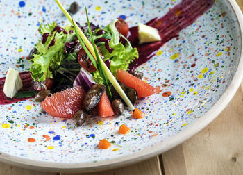 Close-up of salad with quail liver and grapefruit in plate on table