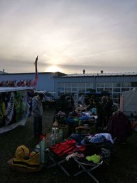 People at beach against sky during sunset