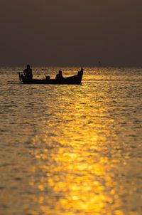 Silhouette boat sailing on sea against sky during sunset