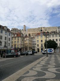 City street by buildings against sky