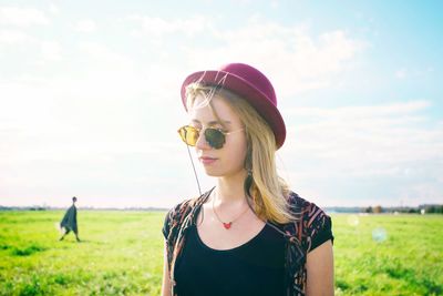 Portrait of beautiful woman on field against sky