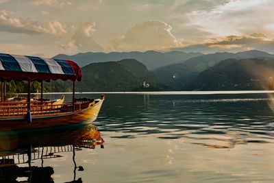 Boats moored in lake against sky