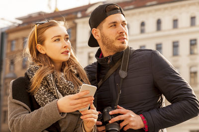 Young man using smart phone in city