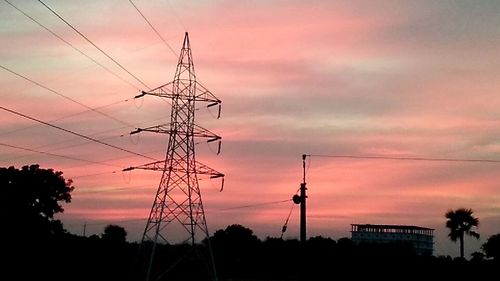 Silhouette of electricity pylon against dramatic sky