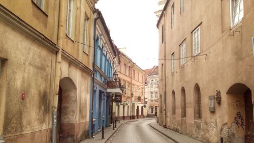 Alley amidst street in city against sky
