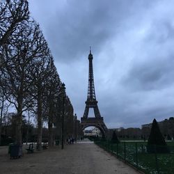 View of tower in city against cloudy sky