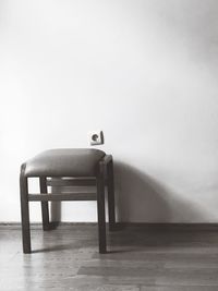 Empty chair on table against wall at home