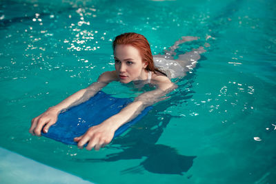 High angle view of young woman swimming in pool