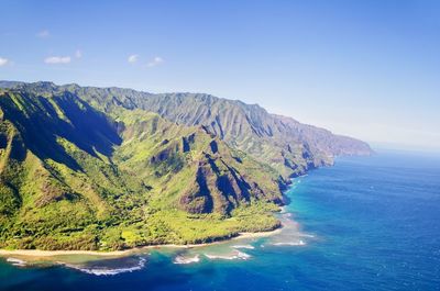 Scenic view of sea and mountains against clear sky