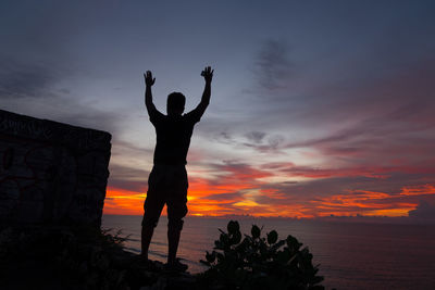 Silhouette man standing against sky during sunset