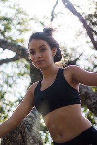 Portrait of young woman against blurred trees