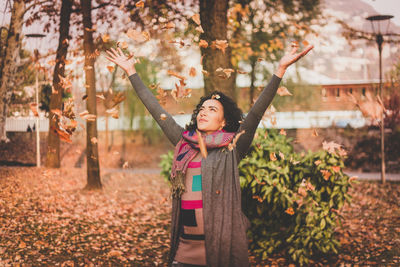 Portrait of smiling young woman standing in park