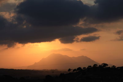 Scenic view of silhouette mountains against sky at sunset