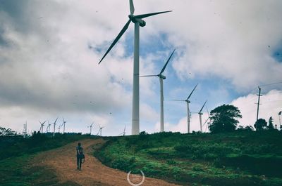 Windmills on field against sky