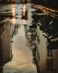 Reflection of buildings on puddle in city