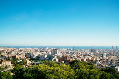 High angle view of city buildings against clear blue sky