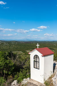 Built structure on landscape against blue sky