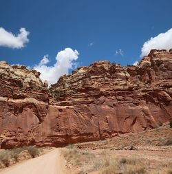 Rock formations on landscape against cloudy sky