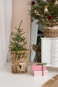 Stylish decor for the christmas room. christmas tree in a wicker basket and gifts with a bow