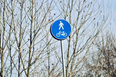 Low angle view of road sign against blue sky