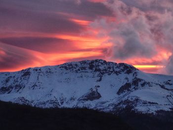 Scenic view of snowcapped mountains against sky during sunset