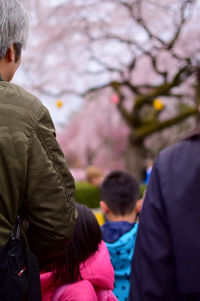 Rear view of man and woman with pink cherry blossom