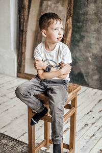 Young little caucasian child with green eyes in a white t-shirt, with a wrist watch