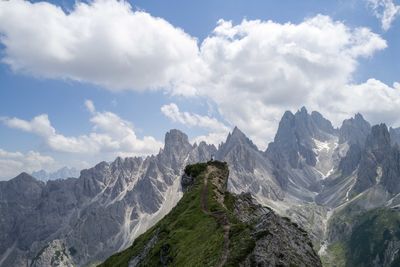 Woman standing on the mountain top overlooking cadini group mountains